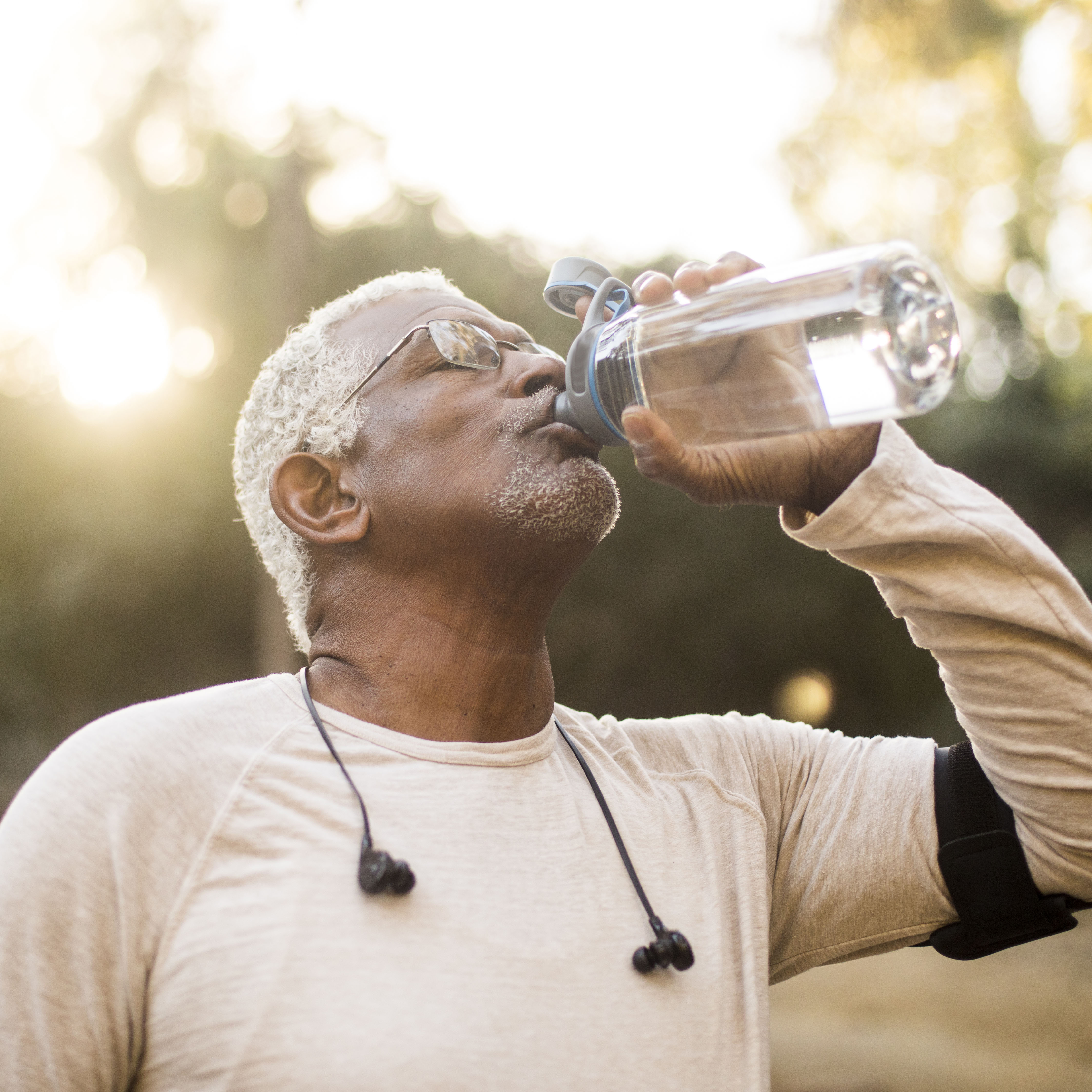 一位年长的非洲裔美国人在锻炼后享受清凉的水。