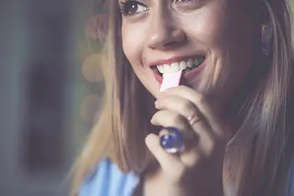 一个把口香糖放进嘴里的女人。