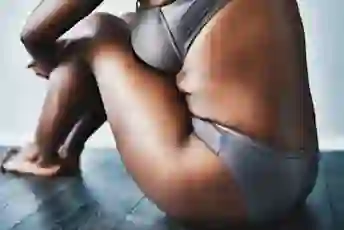 女人穿着银色内衣坐在地板上
