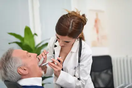 医生检查患者吞咽困难。
