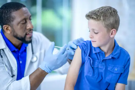 Boy getting vaccinated by his doctor