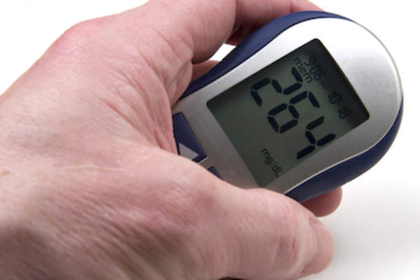 男人保持血糖仪具有高血糖读数。