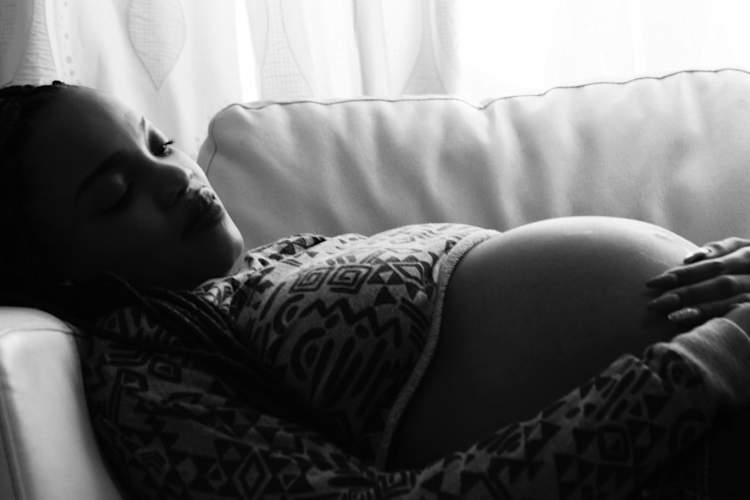 pregnant woman laying on couch