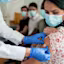 A woman receives a bandage after getting vaccinated