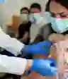 一名妇女在接种疫苗后接受绷带
