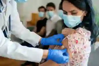 一名妇女在接种疫苗后接受绷带