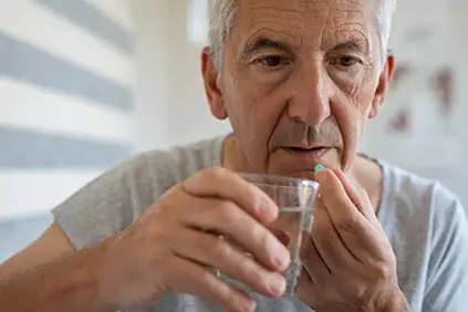 吞下前列腺癌症治疗的口头剂的老人。
