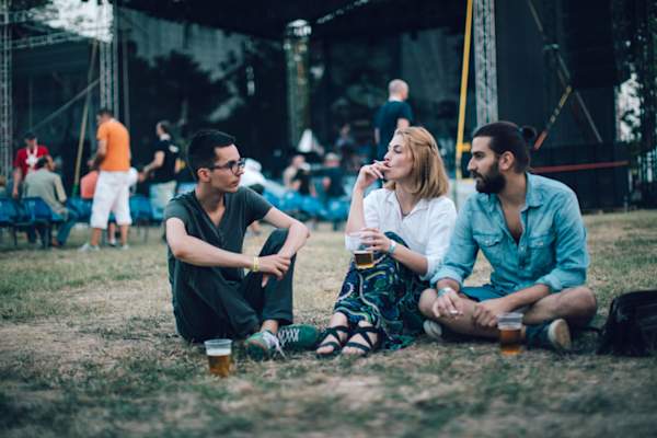 三个朋友在音乐节,有两个抽烟