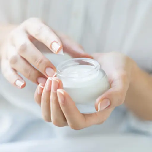 Hands applying moisturizer