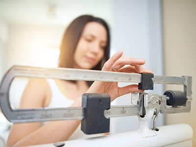女人的规模检查她的体重。