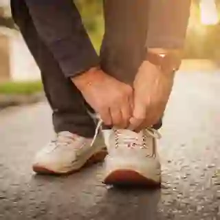 Man out for a walk tying his sneaker.
