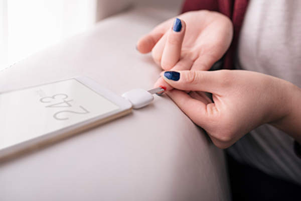 她评定的葡萄糖与她的智能手机。