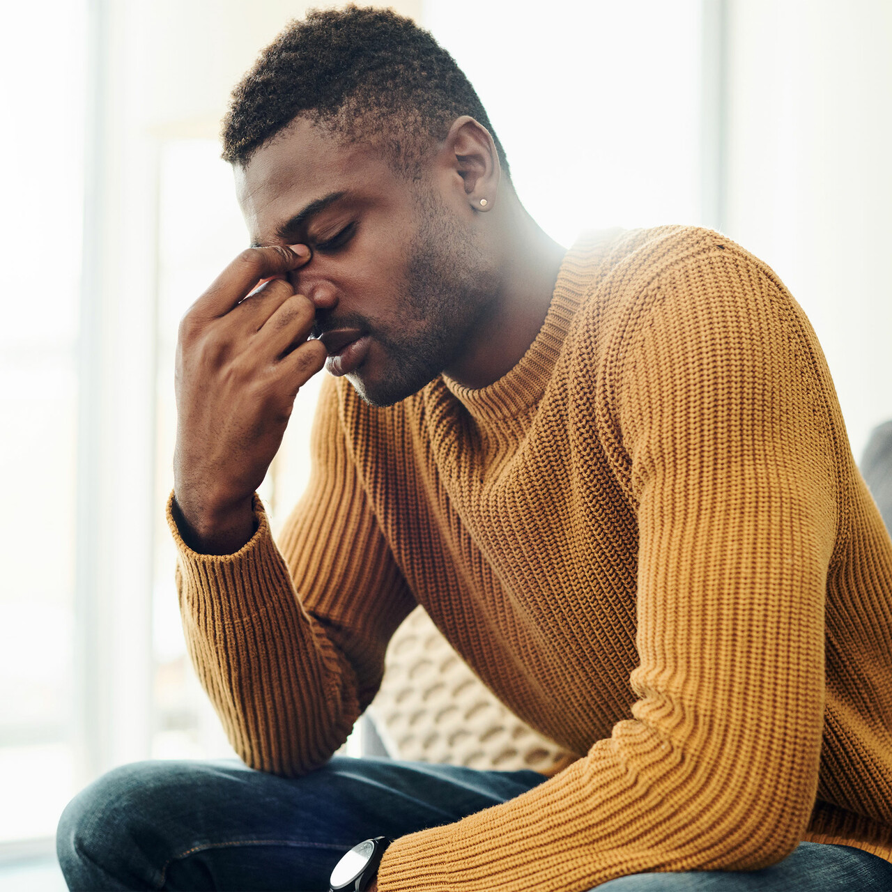 一个生病的男人坐在一个沙发上