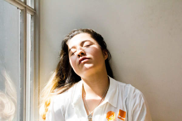 年轻疲惫的女人在阳光下闭着眼睛