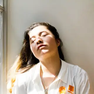 young tired woman with eyes closed in the sun