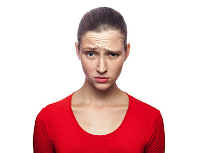 年轻女子用怀疑的表情穿红色衬衫。