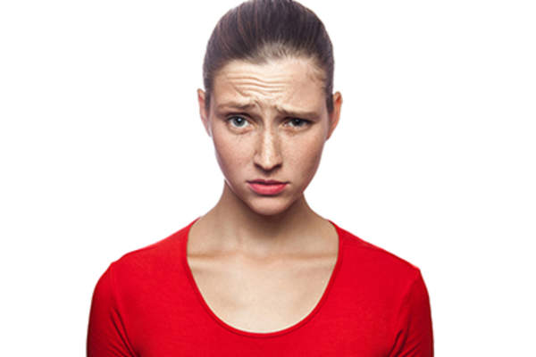 年轻女子用怀疑的表情穿红色衬衫。