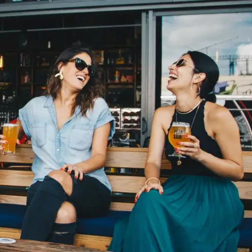 两个女人笑着喝啤酒