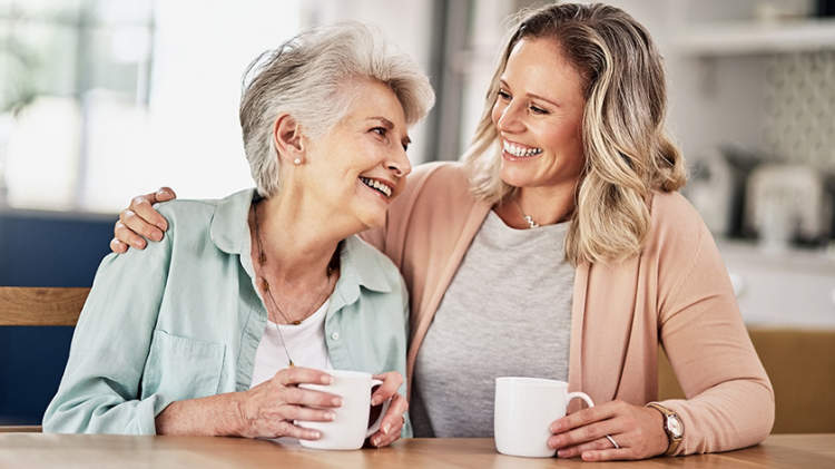 老年妇女和她的看护人一起喝咖啡。
