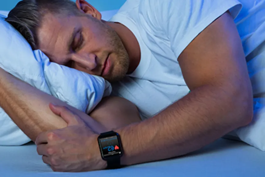 Man sleeping with a sleep tracking device.