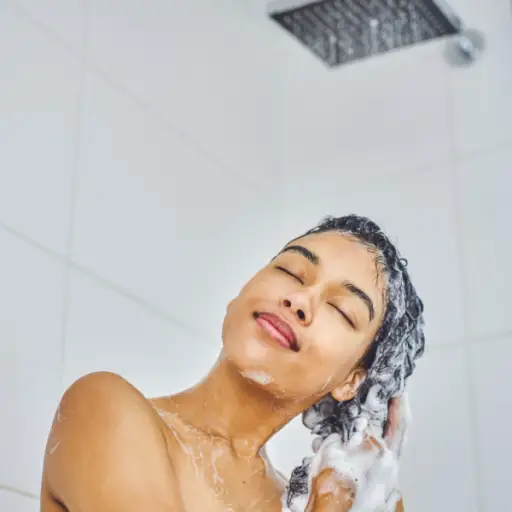 一位年轻的妇女在淋浴间用洗发水洗头