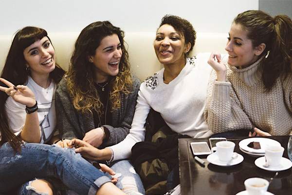 朋友聊天,并在一家咖啡店笑。