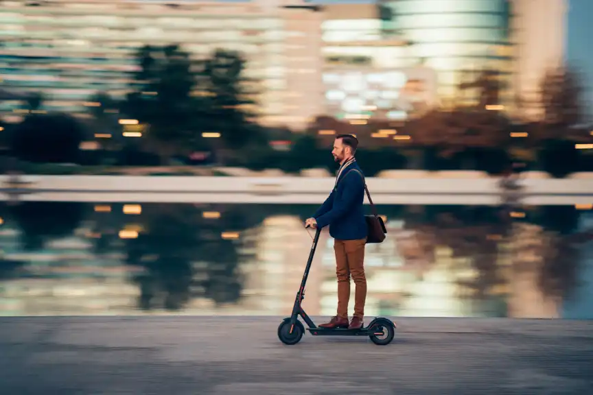 一个男人骑着滑板车穿过城市