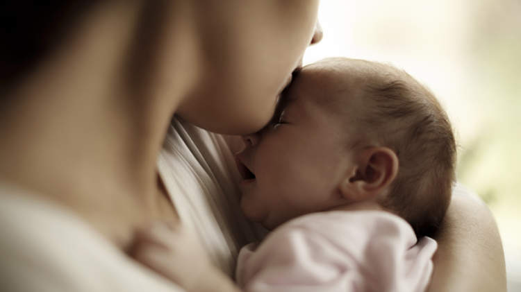 产后抑郁症的母亲抱着刚出生的婴儿。
