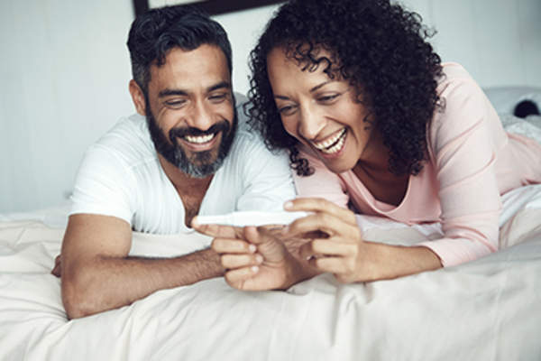 幸福的夫妇阅读妊娠试验在一起。