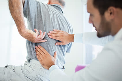 医生评估病人的背部疼痛。