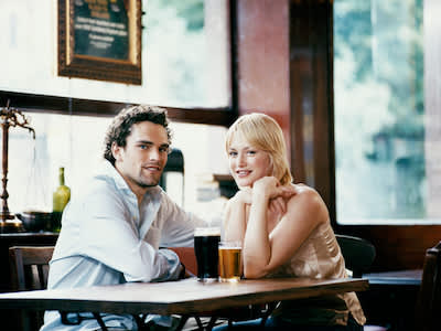 一对年轻夫妇在酒吧里喝啤酒。