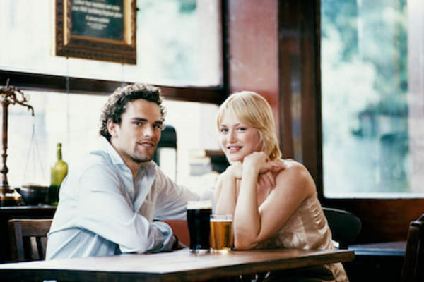 一对年轻夫妇在酒吧里喝啤酒。