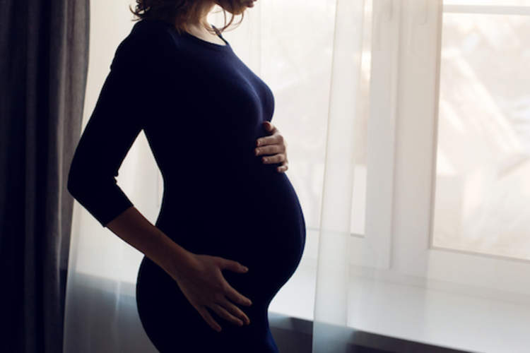 孕妇在窗口前。