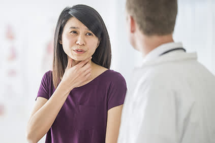 女人讨论咽喉疼痛与她的医生。