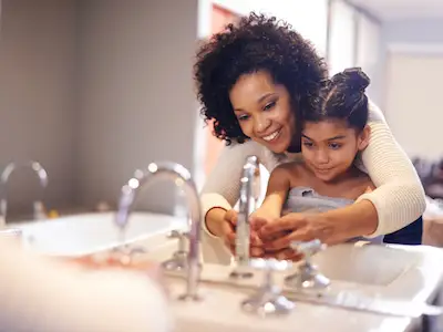 母亲教女儿怎样正确地洗手。