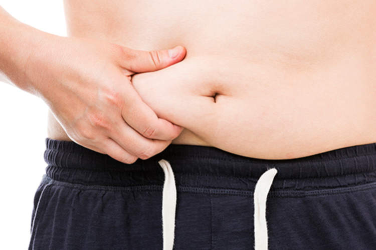男人捏着肚子上的脂肪。