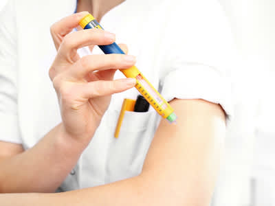 女人注射胰岛素进入臂，使用可调节的胰岛素笔。
