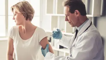 医生给风湿性关节炎患者注射疫苗。
