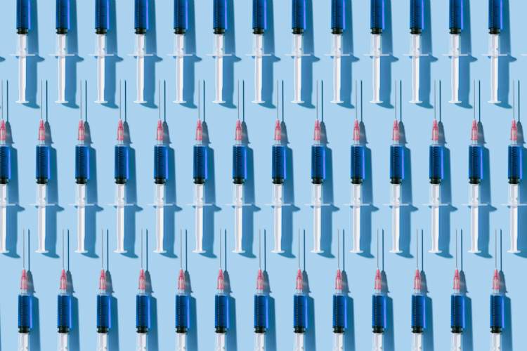 多个注射器组织在蓝色背景上的模式