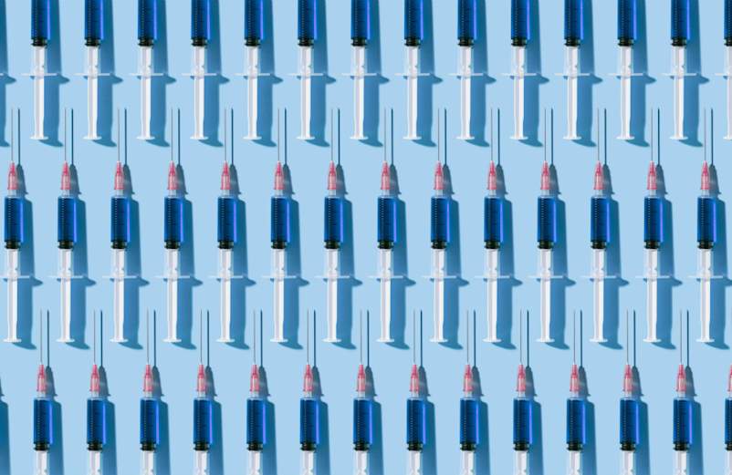 在蓝色背景上以图案组织的多个注射器