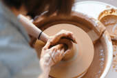 女人的手在轮子上做陶器