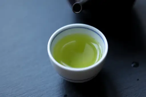茶壶旁边的茶杯里装着绿茶