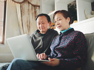 在家高级亚洲夫妇在笔记本电脑。