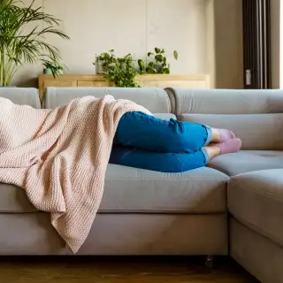 Woman on couch with blanket