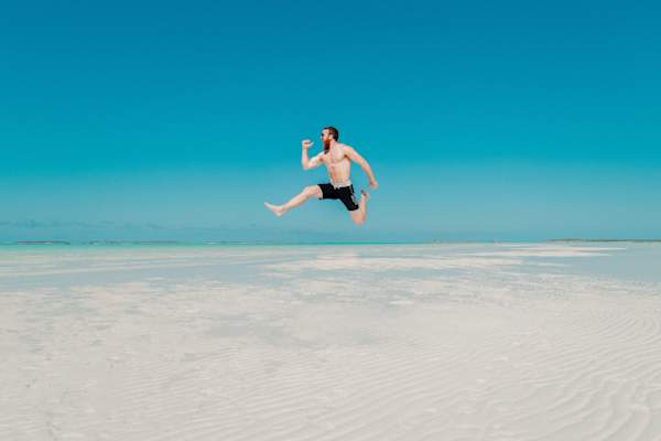 男子在沙滩上跳跃