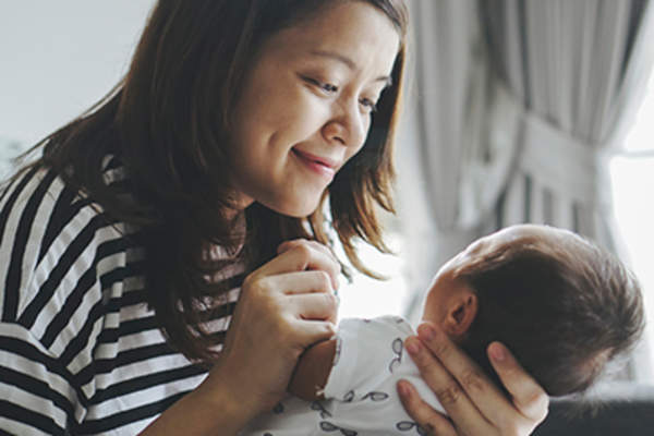 母亲微笑在她的婴儿。