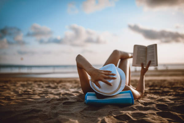 女性阅读和欣赏日落海滩的海洋“>
              </picture>
             </header>
             <figcaption class=