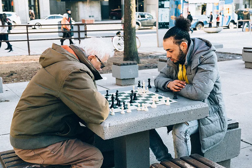年轻人和老人在公园里下棋