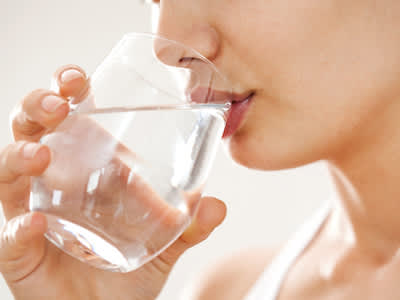 女人喝一杯水，保持水合是健康眼睛的重要。