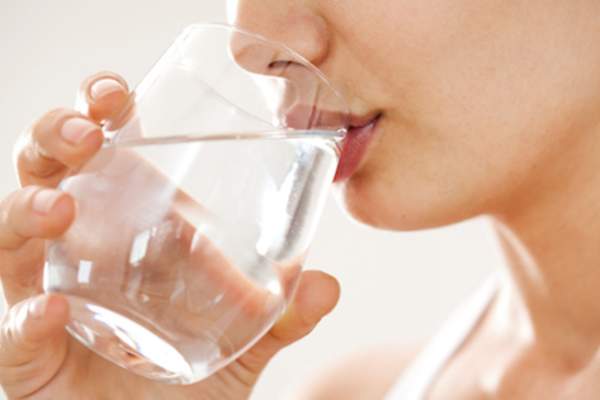 女人喝一杯水，保持水分对眼睛健康很重要。